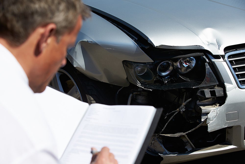 A service expert examines vehicle damage